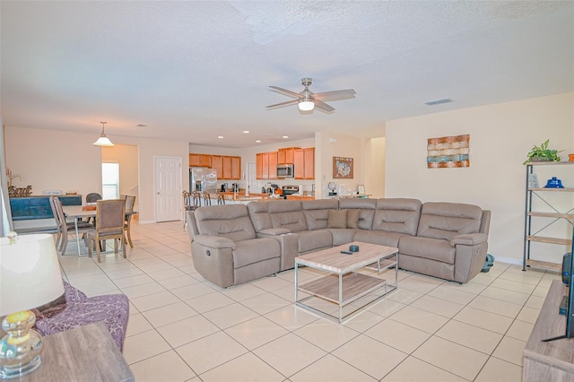 living area with ceiling fan, light tile patterned floors, recessed lighting, and a textured ceiling