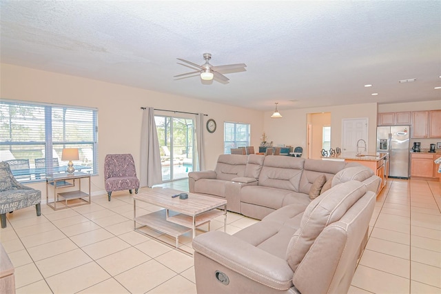 living area featuring light tile patterned flooring, recessed lighting, a textured ceiling, and ceiling fan