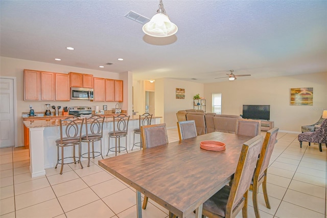 dining space featuring light tile patterned floors, a ceiling fan, a textured ceiling, and recessed lighting