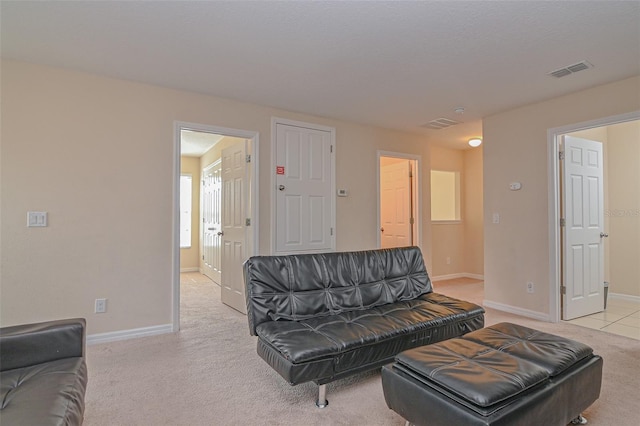 living area with baseboards, visible vents, and light carpet