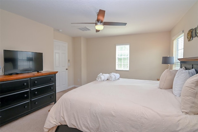 bedroom with visible vents, light carpet, and a ceiling fan