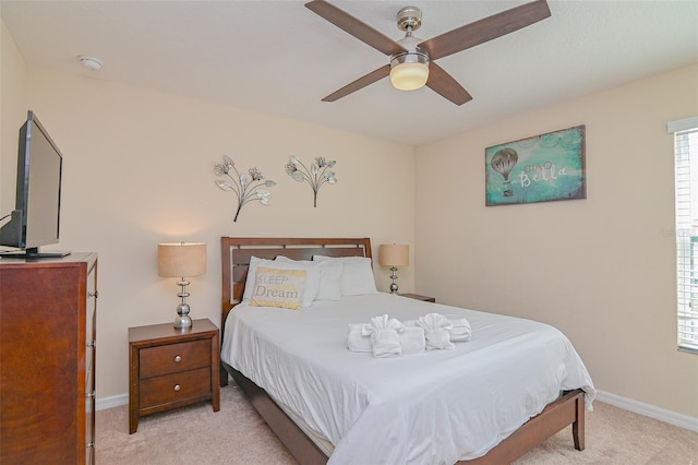 bedroom with baseboards, light carpet, and a ceiling fan