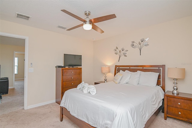 bedroom featuring a ceiling fan, baseboards, visible vents, and light carpet