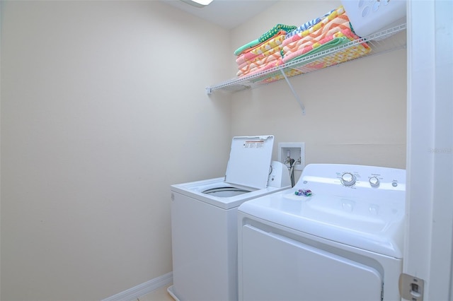 washroom featuring baseboards, laundry area, and washer and clothes dryer