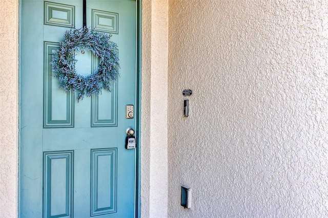 view of exterior entry with stucco siding