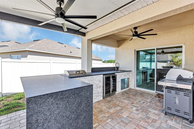 view of patio with a sink, a grill, beverage cooler, and fence