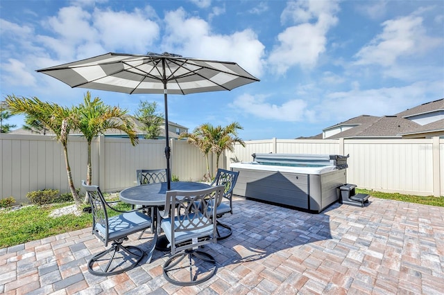 view of patio / terrace featuring a hot tub, outdoor dining area, and a fenced backyard