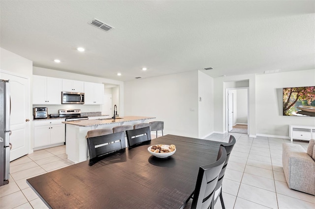 dining room featuring light tile patterned floors, recessed lighting, visible vents, and a textured ceiling