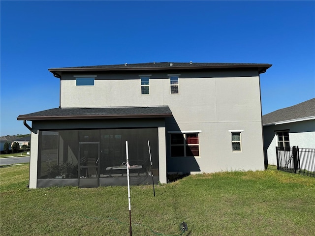 back of house with a yard, fence, stucco siding, and a sunroom