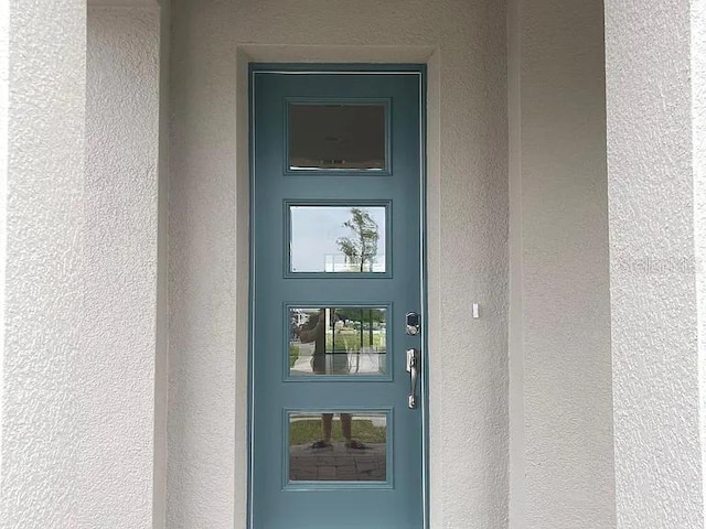 property entrance with stucco siding