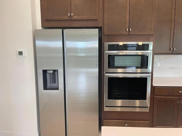 kitchen featuring light countertops, tasteful backsplash, and stainless steel appliances