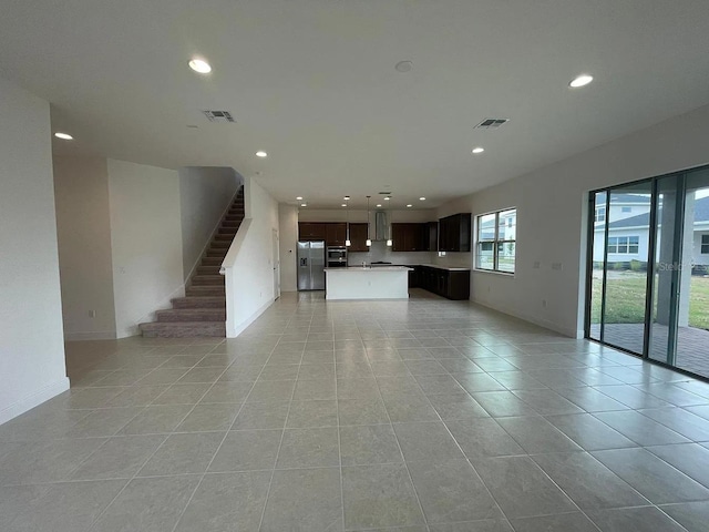 unfurnished living room with light tile patterned floors, visible vents, recessed lighting, and stairway