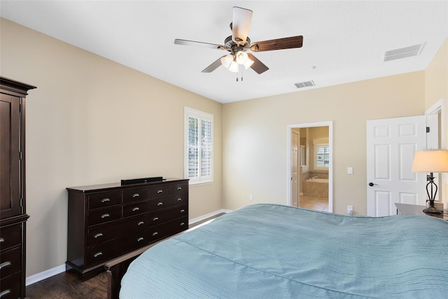 bedroom with baseboards, visible vents, dark wood-style flooring, and connected bathroom