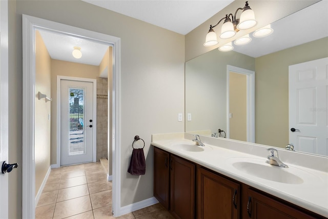 full bath featuring a sink, baseboards, double vanity, and tile patterned flooring