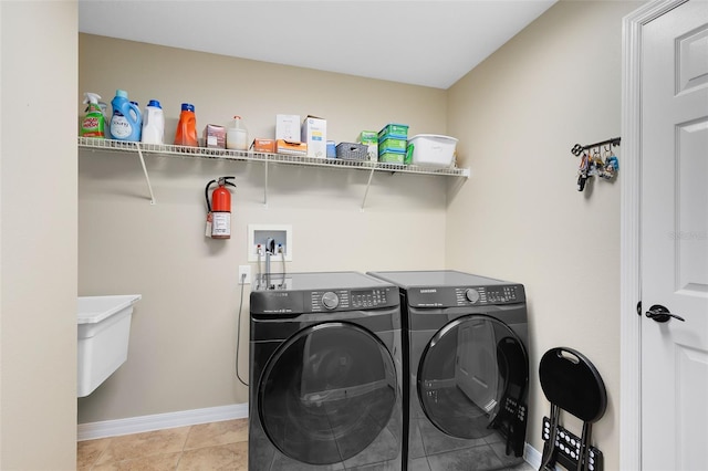 laundry area with washer and dryer, baseboards, laundry area, and light tile patterned floors