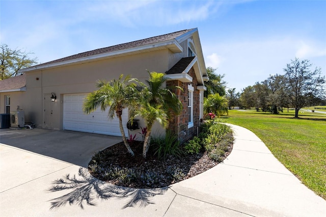 view of side of home featuring an attached garage, stucco siding, concrete driveway, stone siding, and a lawn