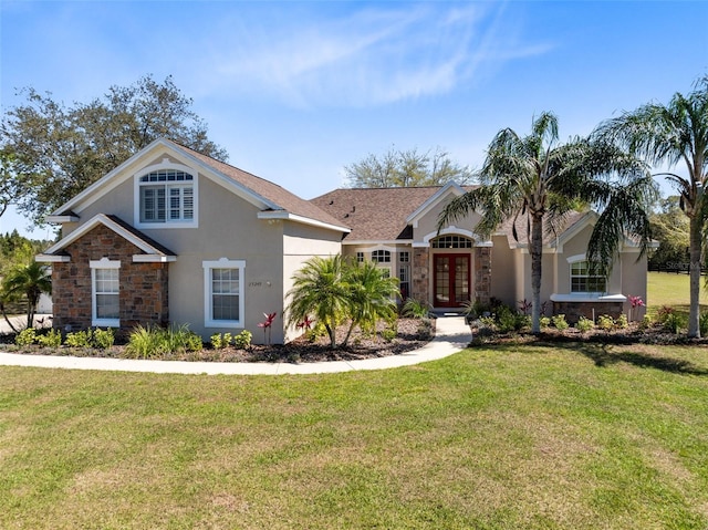 view of front of house with french doors, stone siding, a front lawn, and stucco siding