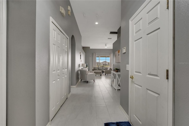 corridor with visible vents, recessed lighting, baseboards, and arched walkways