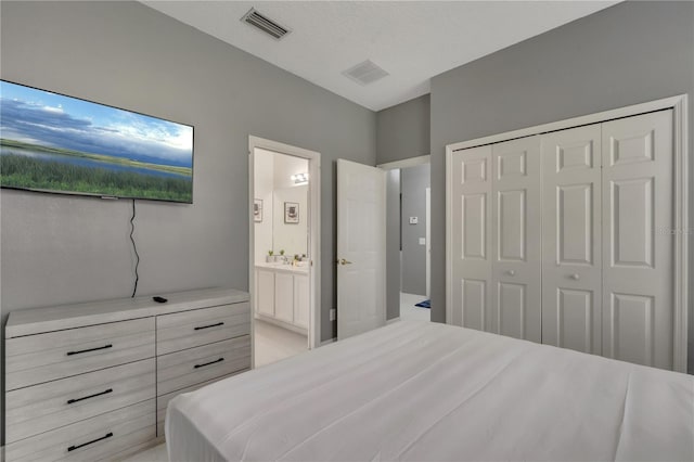 bedroom featuring a closet, visible vents, and ensuite bathroom