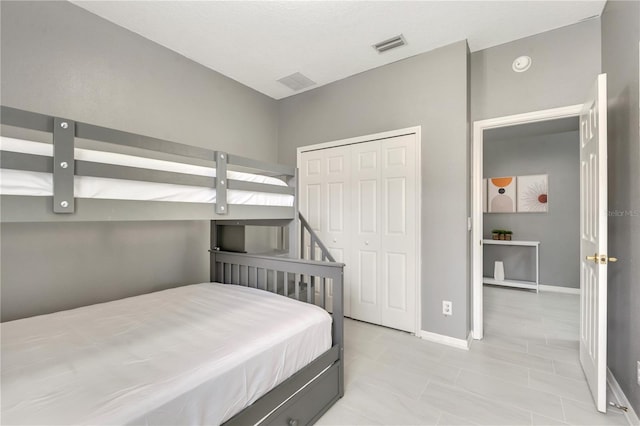 bedroom featuring baseboards, visible vents, and a closet