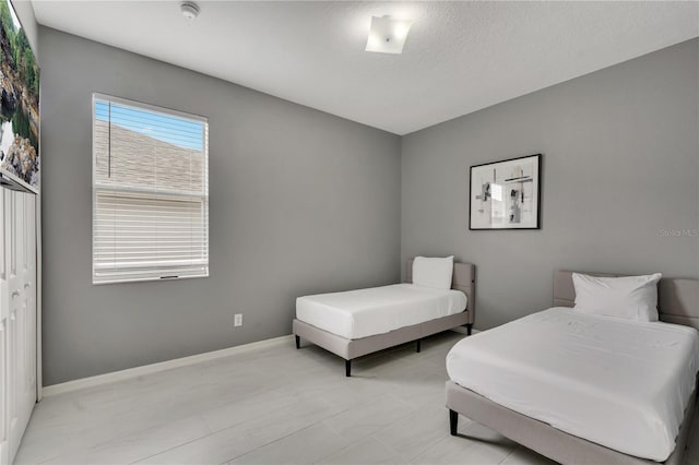 bedroom with baseboards and a textured ceiling