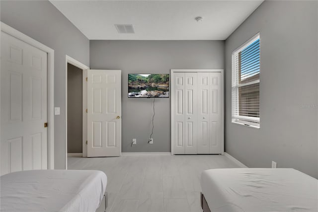 bedroom featuring visible vents, baseboards, and a closet