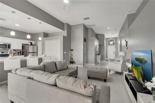 living room featuring baseboards, visible vents, and arched walkways