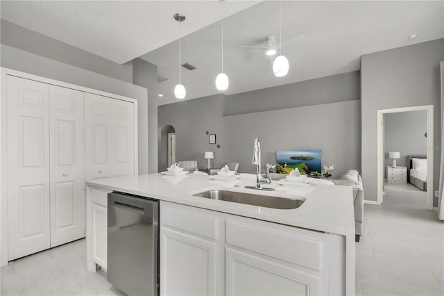 kitchen featuring visible vents, a sink, open floor plan, white cabinetry, and stainless steel dishwasher