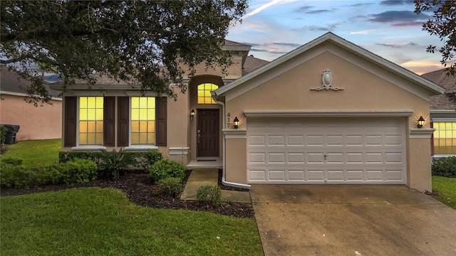 view of front of property featuring stucco siding, driveway, and a garage