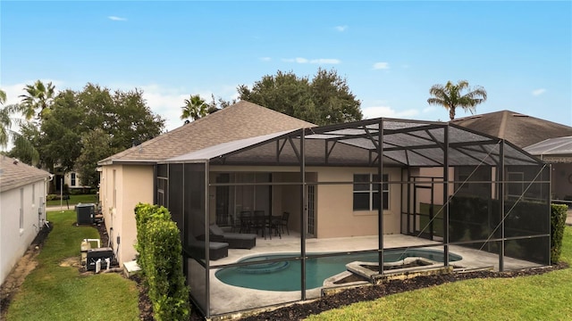 back of house featuring stucco siding, cooling unit, glass enclosure, and a patio