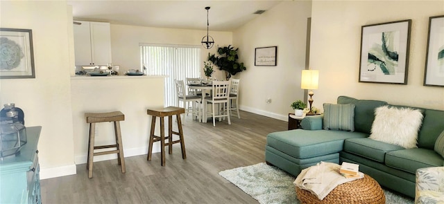 living area featuring visible vents, baseboards, and wood finished floors