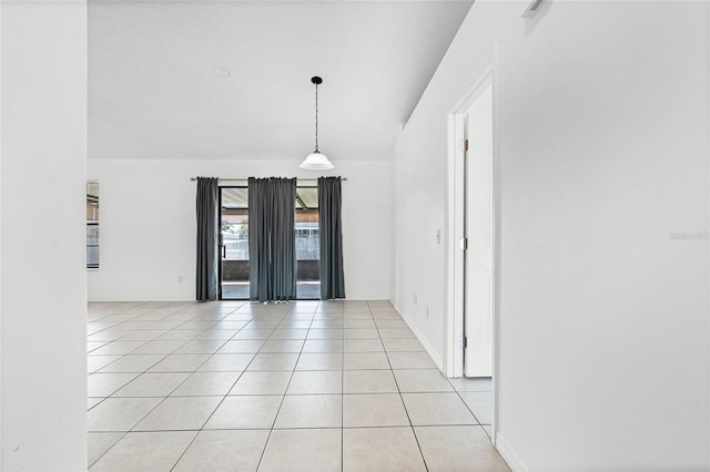 spare room with baseboards and light tile patterned flooring