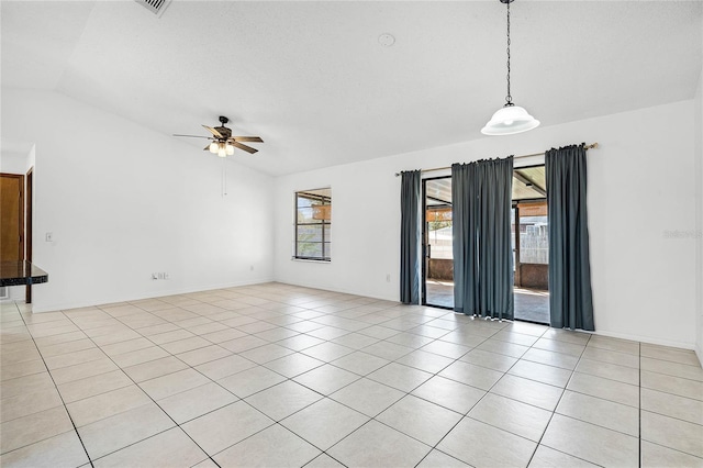 spare room with light tile patterned floors, ceiling fan, baseboards, and lofted ceiling