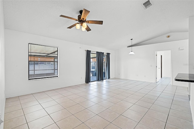 empty room featuring a wealth of natural light, visible vents, a ceiling fan, and light tile patterned floors