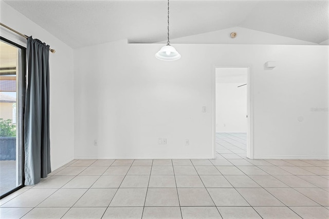 unfurnished room featuring lofted ceiling and light tile patterned floors