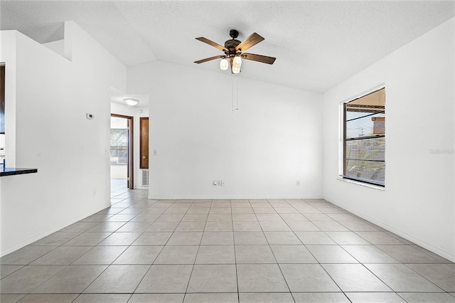 unfurnished room featuring lofted ceiling, a textured ceiling, light tile patterned flooring, and a ceiling fan