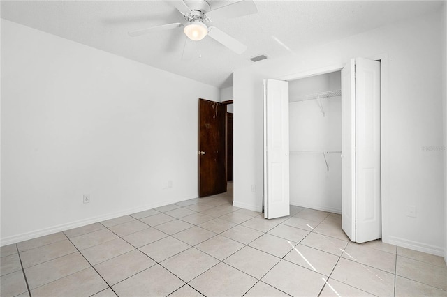 unfurnished bedroom featuring visible vents, a ceiling fan, a closet, light tile patterned floors, and baseboards