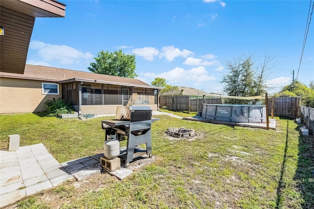 view of yard featuring a fenced in pool, a fenced backyard, and a sunroom