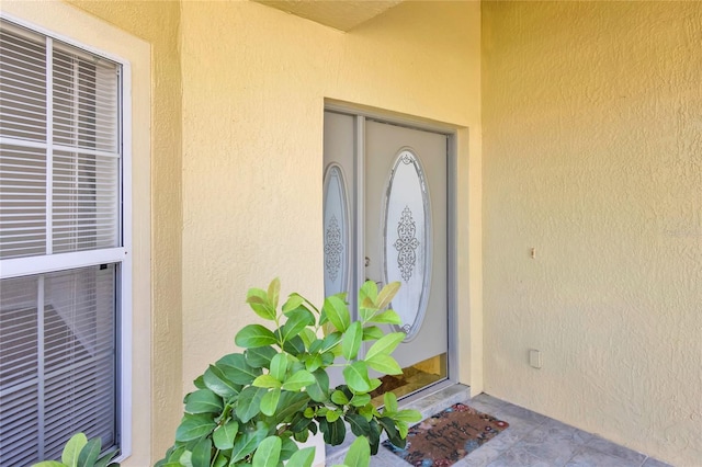 view of exterior entry with stucco siding