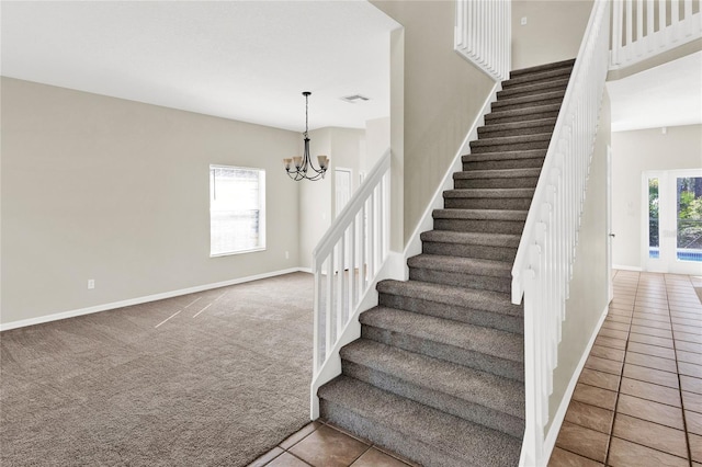 stairway with tile patterned flooring, visible vents, baseboards, a chandelier, and carpet flooring