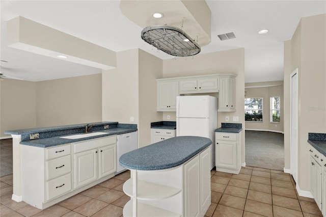 kitchen featuring white appliances, visible vents, a sink, white cabinetry, and dark countertops