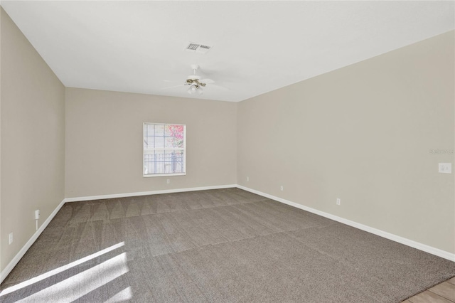 empty room with visible vents, carpet flooring, baseboards, and ceiling fan