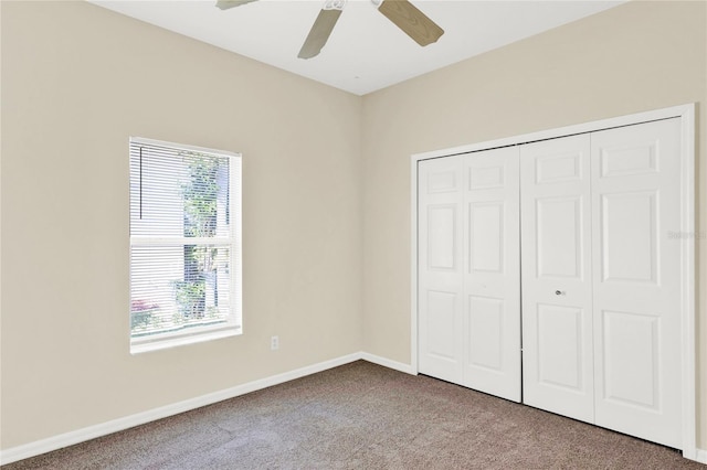 unfurnished bedroom featuring a closet, a ceiling fan, baseboards, and carpet floors