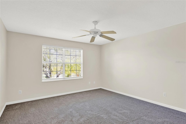 empty room featuring baseboards, ceiling fan, and dark colored carpet