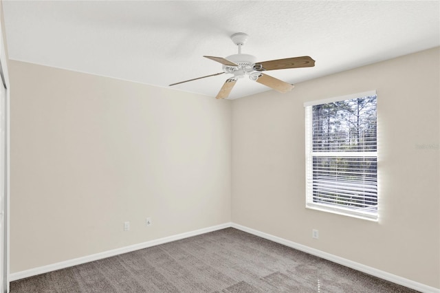 empty room featuring a ceiling fan, baseboards, and carpet floors