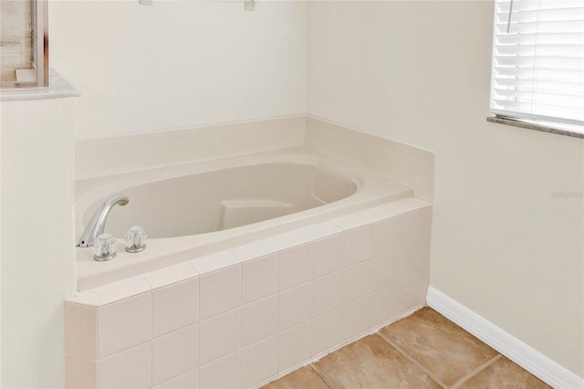 bathroom featuring tile patterned floors, baseboards, and a bath