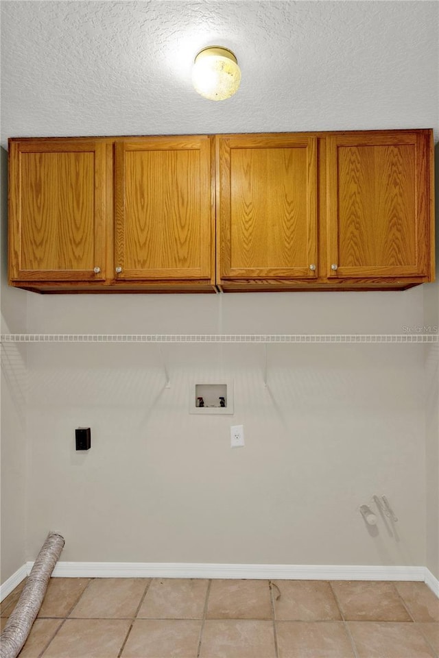 clothes washing area featuring light tile patterned floors, baseboards, cabinet space, electric dryer hookup, and washer hookup