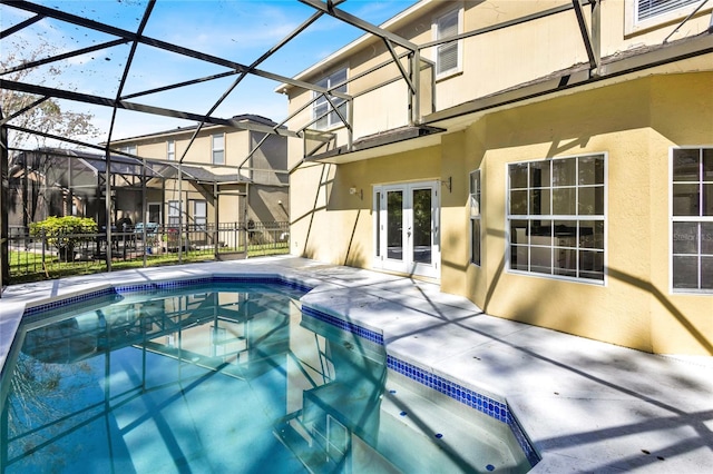 outdoor pool with french doors, fence, a lanai, and a patio area