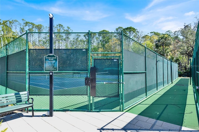 view of sport court featuring fence and a gate