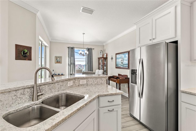 kitchen featuring stainless steel fridge with ice dispenser, light wood-type flooring, ornamental molding, white cabinetry, and a sink